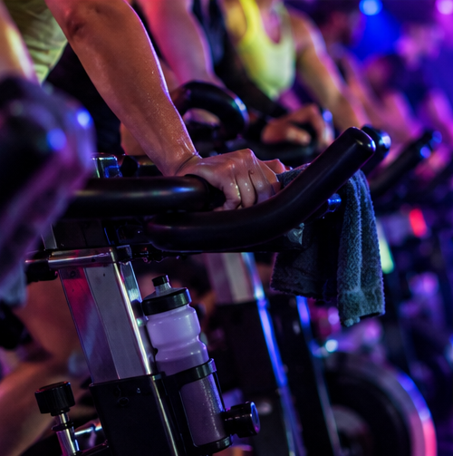 Indoor cycling riders training together in a dark studio